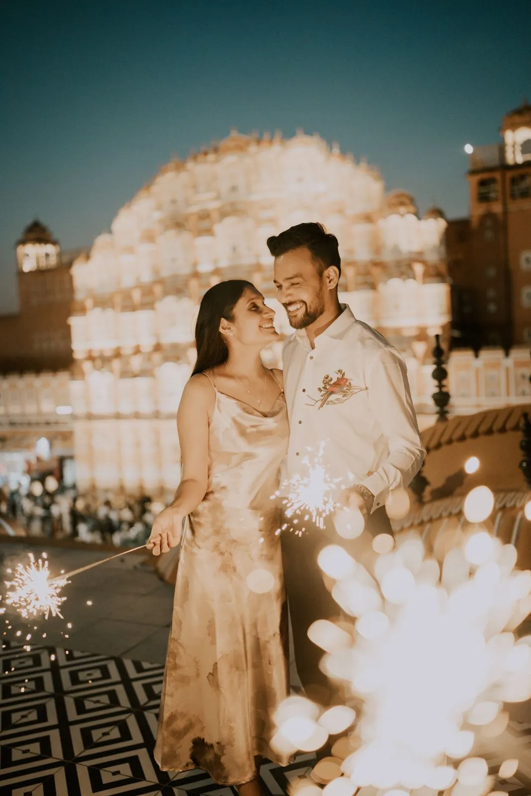Couple with sparklers in front of the lit-up Hawa Mahal at night