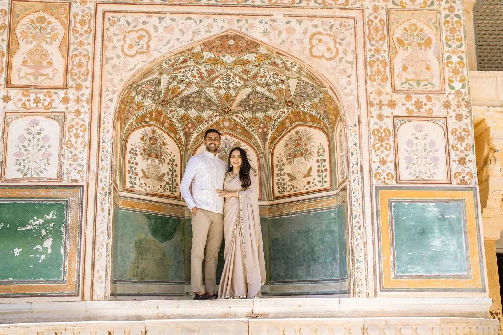 Couple in front of a painted archway at Amer Fort during a Jaipur pre-wedding shoot